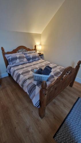 a large wooden bed with blue pillows in a bedroom at Apple Lodge Apartment in Forkill