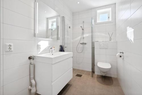a white bathroom with a sink and a toilet at Studio Seaside in Tromsø