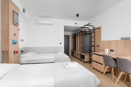 Pokój z 2 łóżkami, biurkiem i krzesłami w obiekcie Centralny Ośrodek Sportu - Wałcz w Wałczu
