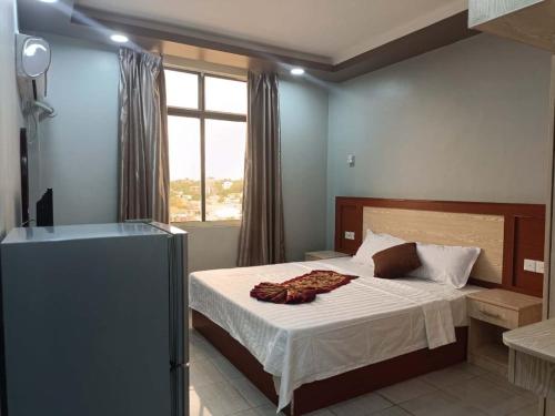 Schlafzimmer mit einem Bett mit weißer Bettwäsche und einem Fenster in der Unterkunft EASTERN PLAZA HOTEL in Juba