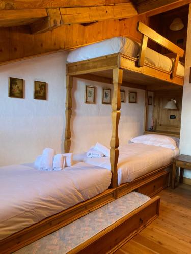 two bunk beds in a room with wooden ceilings at Appartamento Laura in Madonna di Campiglio