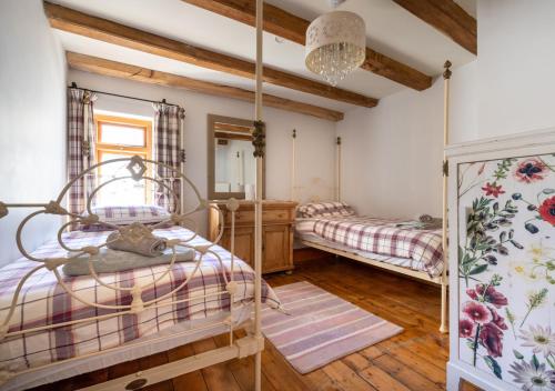 um quarto com 2 camas e um lustre em Wall Cottage Group em Tenby