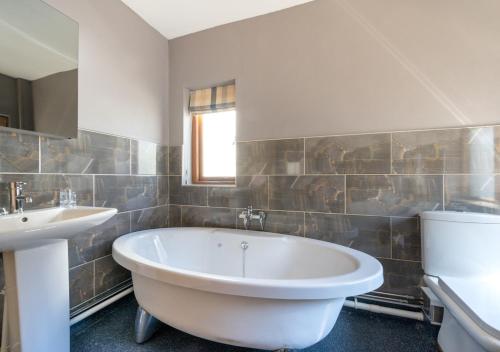 uma casa de banho com uma banheira e um lavatório em Wall Cottage Group em Tenby