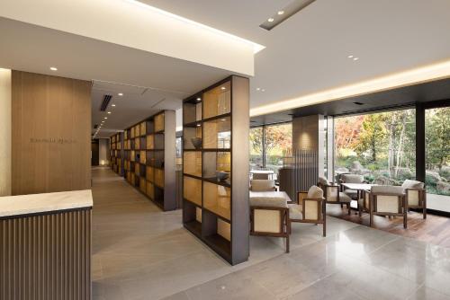 a hallway with a library with chairs and tables at Hotel Okura Kyoto Okazaki Bettei in Kyoto