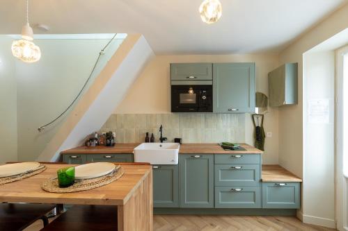 a kitchen with blue cabinets and a wooden table at Charme Provinois in Provins