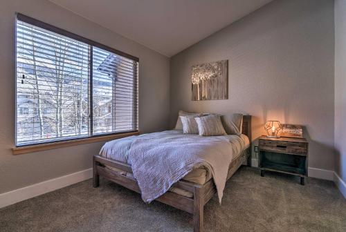a bedroom with a bed with a nightstand and a window at Waterfront Home with Scenic Views in Silverthorne in Silverthorne