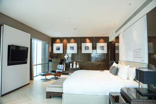 a bedroom with a large bed and a tv at Le Meridien Bangkok in Bangkok
