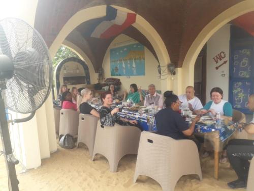 eine Gruppe von Menschen, die an einem Tisch in einem Restaurant sitzen in der Unterkunft El Prince Guesthouse in Assuan