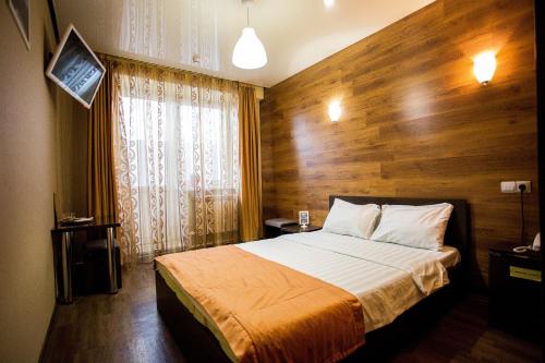 ウラン・ウデにあるHotel Kochevnik na Zherdevaの木製の壁のベッドルーム1室(ベッド1台付)