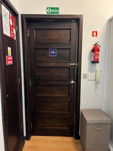 a wooden door with a sign on it in a room at Espaço_Zero [Downtown] in Porto