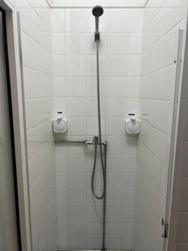 a shower in a white tiled bathroom with a shower head at Espaço_Zero [Downtown] in Porto