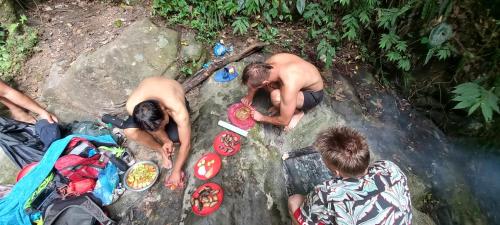 a group of people sitting on a rock next to a waterfall at Hostel Swastik in Bhaktapur