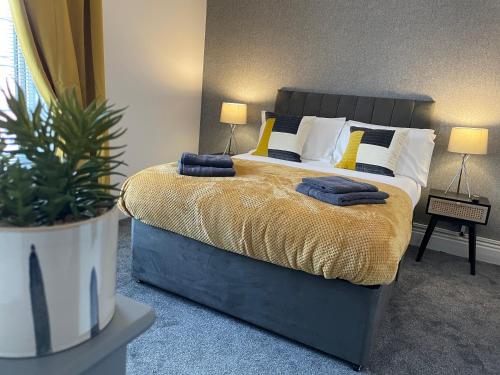 1 dormitorio con 1 cama con 2 almohadas y planta en Byelands House en Middlesbrough