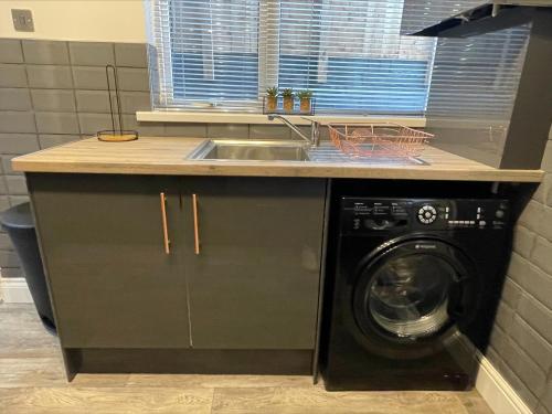 a kitchen with a sink and a washing machine at Byelands House in Middlesbrough