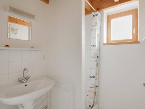 W białej łazience znajduje się umywalka i lustro. w obiekcie Maison Luz-Saint-Sauveur, 3 pièces, 4 personnes - FR-1-402-40 w mieście Luz-Saint-Sauveur