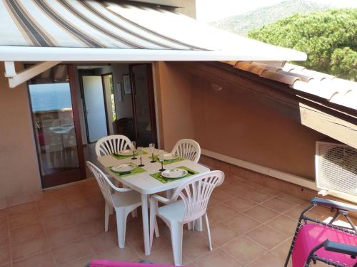 une table blanche et des chaises sur un balcon dans l'établissement T1 Mezzanine Climatisé avec Terrasse et Parking - St Clair, Lavandou - FR-1-308-80, au Lavandou