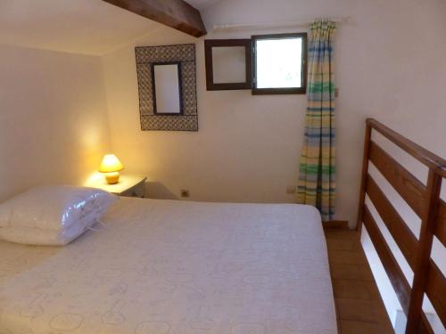 une chambre avec un grand lit et une fenêtre dans l'établissement T1 Mezzanine Climatisé avec Terrasse et Parking - St Clair, Lavandou - FR-1-308-80, au Lavandou