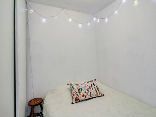 - une chambre dotée d'un lit avec un oreiller et des lumières dans l'établissement Studio cabine avec parking proche centre Luz-Saint-Sauveur, balcon, pour 4 pers. - FR-1-402-66, à Luz-Saint-Sauveur