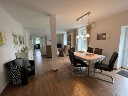 een eetkamer en een woonkamer met een tafel en stoelen bij Little Cottage in Visselhövede