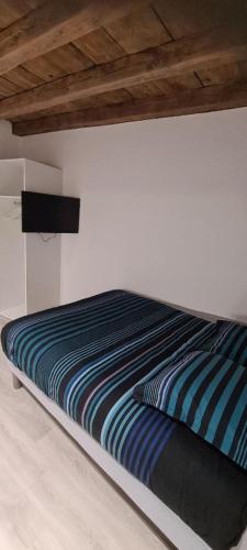 - un lit avec une couette à rayures bleues dans une chambre dans l'établissement STUDIO CLIMATISATION Vieille Ville, à Lyon