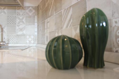 two green vases sitting on a counter in a kitchen at San Bartolomeo Apartment in Pistoia