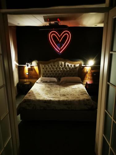 a bedroom with a bed with a heart sign on it at Sweet home San Filippo Industry Style in centro città in Biella