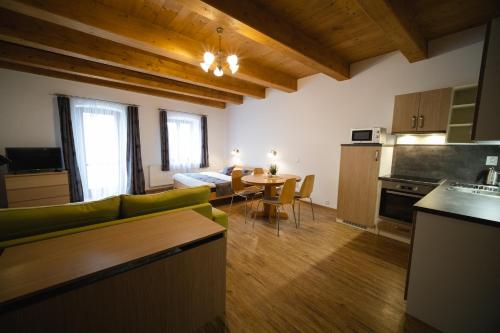 Apartmany 21 Třeboň في تريبون: مطبخ وغرفة معيشة مع طاولة وأريكة