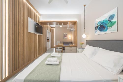 um quarto com uma cama grande com duas toalhas em Pale Orb Properties (1) em Atenas