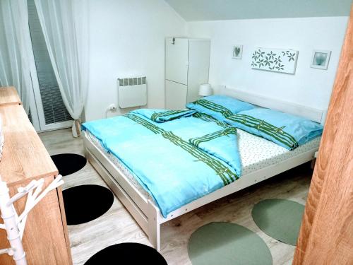 a bedroom with a large bed with blue sheets at Apartmán Romanna in Terchová