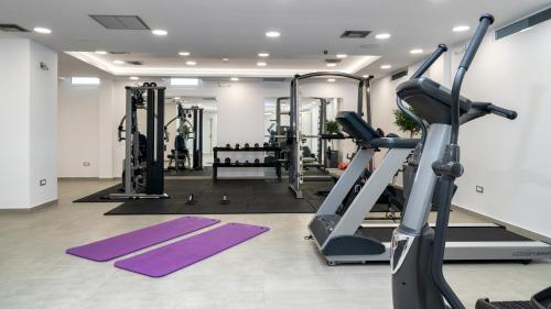 a gym with several tread machines and purple mats at Acharavi Beach Hotel in Acharavi