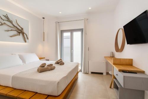 a bedroom with a bed with two teddy bears on it at Barbarigos luxury spa apartments in Naousa