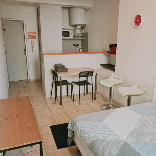 uma pequena cozinha com mesa e cadeiras num quarto em Kimme Orange - Plein centre ancien em Orléans