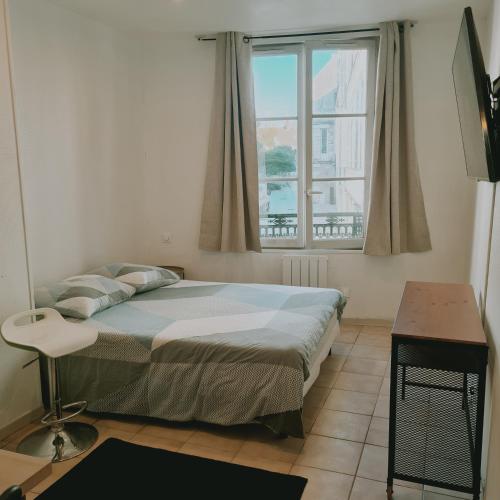 um quarto com uma cama e uma janela em Kimme Orange - Plein centre ancien em Orléans