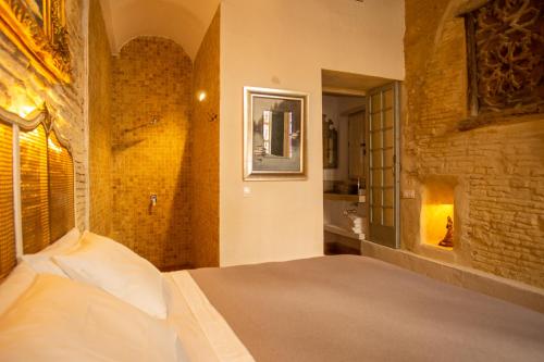 a bedroom with a bed and a brick wall at Apartamentos Sharis in Jerez de la Frontera
