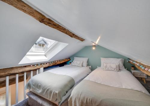 a attic bedroom with two beds and a window at Tanyrallt in Dinas Mawddwy