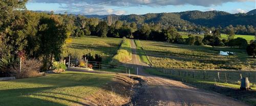 una strada vuota in un campo con montagne sullo sfondo di The Cottage Country Escape a Coolabine