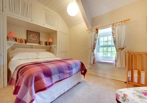 a bedroom with a bed and a window at Ynys Pandy in Llanfihangel-y-pennant