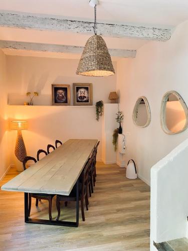 une salle à manger avec une table et des chaises en bois dans l'établissement Le Mas des Sources, à Saint-Sèbastien