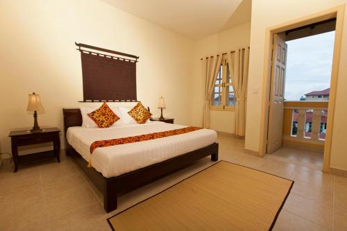 a bedroom with a large bed and a large window at Grand Residence in Phnom Penh