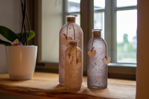 three glass bottles sitting on a wooden table at außergewöhnliches, historisches, spätgotisches Wohnhaus von 1519, Gries 5 in Gera