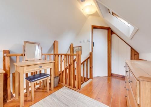 a room with a staircase with a table and a desk at Pigsty Cottage in Knelston