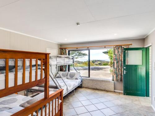 Tango10 Accommodation - Best views in Hawke's Bay في Tangoio: غرفة نوم بسريرين بطابقين ونافذة
