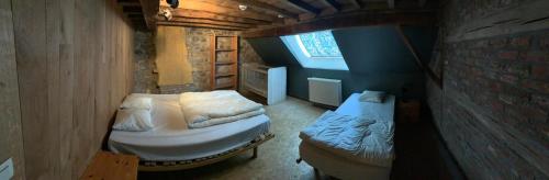 Cette petite chambre comprend 2 lits et une fenêtre. dans l'établissement Ferme Leclercqz, à Le Mesnil