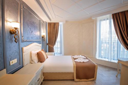 um quarto com uma cama grande e uma janela grande em Istanbul My Assos Hotel em Istambul