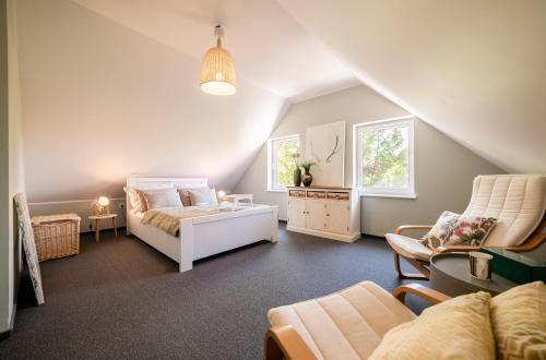 ルビャトボにあるWydmowe Zaciszeの屋根裏のベッドルーム(ベッド1台、椅子付)