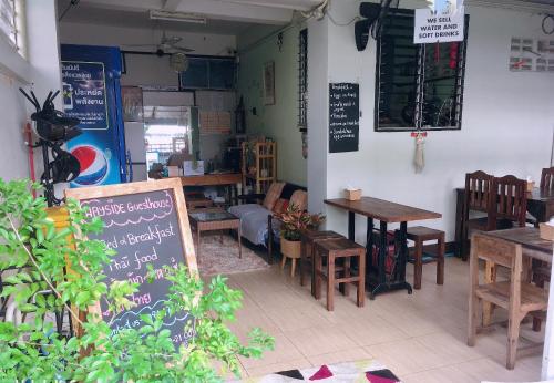a restaurant with tables and chairs and a chalkboard at Wayside Guesthouse in Chiang Mai