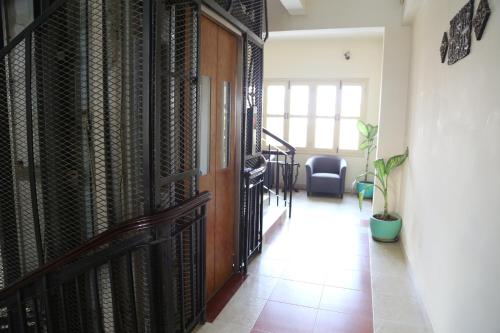 a hallway with a door to a room with a chair at Grand Residence in Phnom Penh