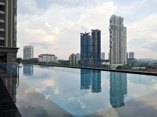 a swimming pool with a city skyline in the background at SKS Pavillion 1Bedroom High Floor @2pax By HAUZ CINTA in Johor Bahru