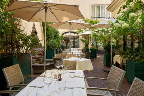 a restaurant with tables and chairs and umbrellas at Hôtel Regina Louvre in Paris
