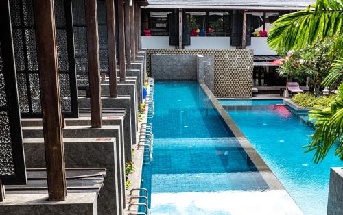 a swimming pool with chairs in a building at Am Samui Palace in Lamai